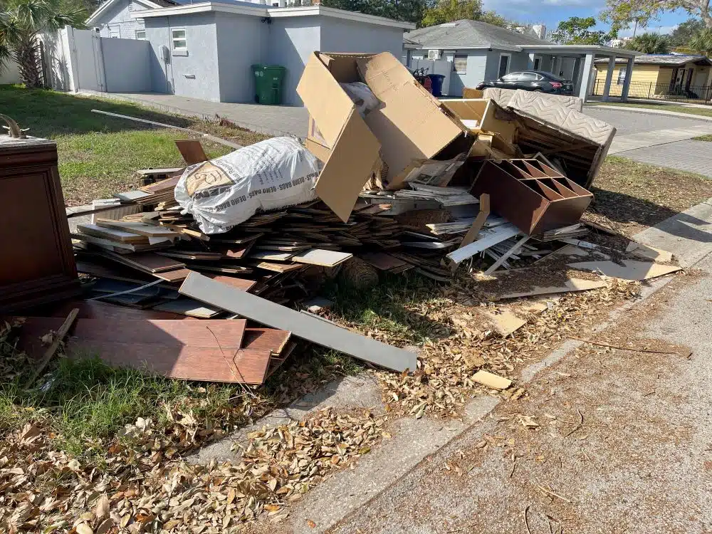A pile of hurricane-damaged items, including furniture and appliances, indicating the aftermath of the storm.