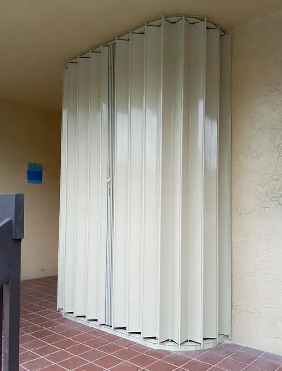 residential-commercial-window-treatment-installer Accordion shutter protecting window