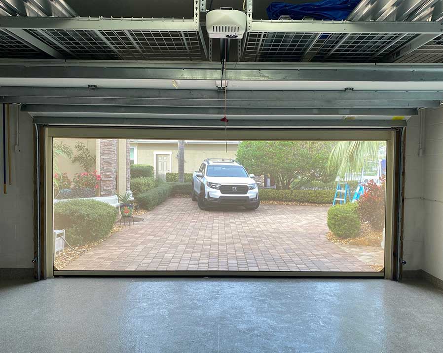 outdoor-pool-house-screens From inside garge door looking through a screen with car parked on brick driveway