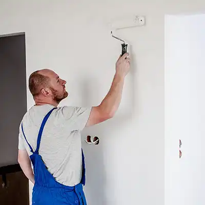 Painter rolling a white wall